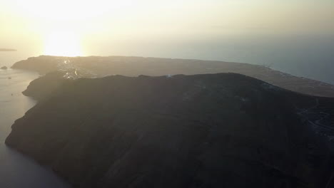 rising sunset aerial of mountain top profet elias church on santorini