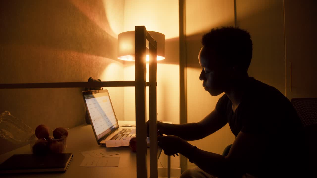 Focused young black man using laptop computer for online work or communication