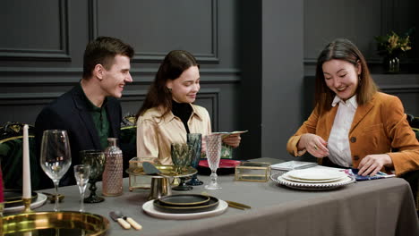 Asian-woman-talking-with-a-couple-sitting-at-a-table