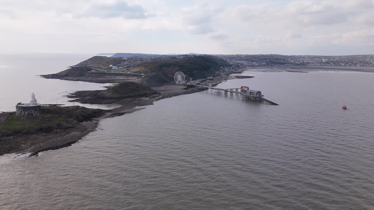 Aerial panoramic approach to the Big Wheel at Mumbles Pier, showing details of the structure and movement under cloudy sky