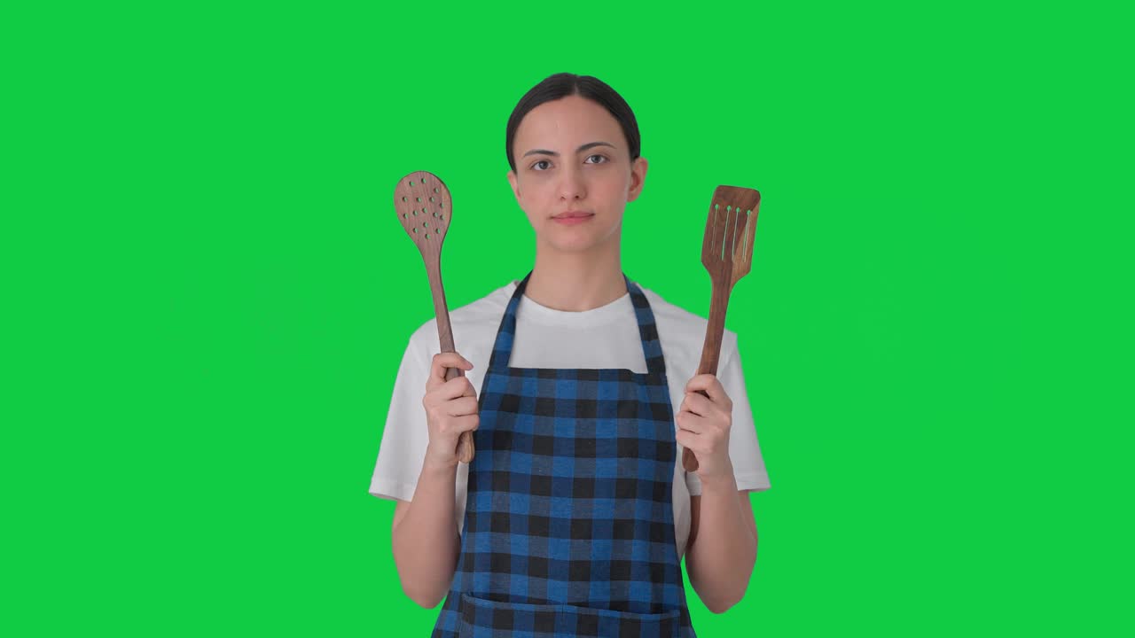 Indian housewife posing with spoon and spatula Green screen