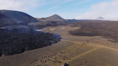 large group of tourists standing near active lava field in iceland