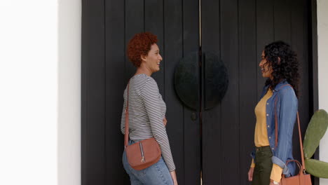 opening door, woman welcoming diverse female friends into home, smiling and excited