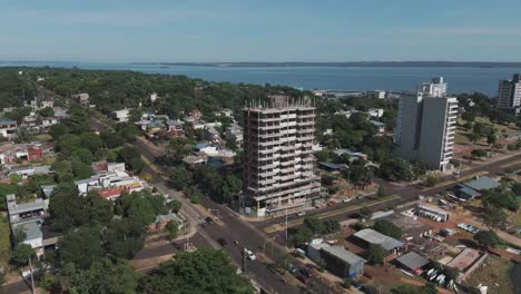 Drohnenaufnahmen-Fangen-Die-Dynamische-Landschaft-Der-Stadtentwicklung-In-Der-Nähe-Des-Paraná-Flusses-Ein-Und-Zeigen-Baustellen,-Belebte-Straßen,-Lebhaften-Verkehr,-üppiges-Grün-Und-Charmante-Wohngebiete.