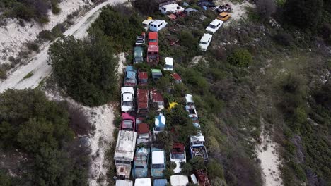 car graveyard, aerial view of junked antique cars in a forest lot