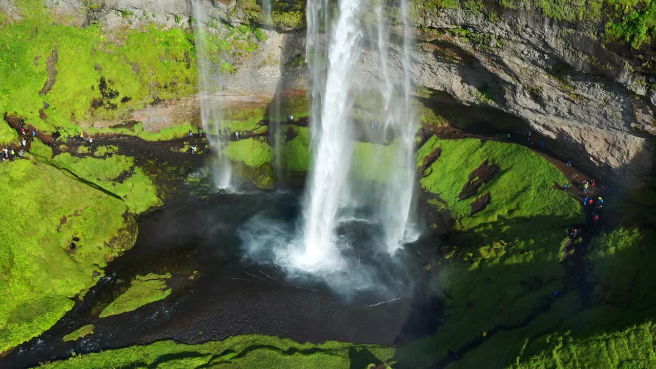 impresionantes cascadas con gente haciendo turismo en un día soleado en seljalandsfoss, costa sur de islandia