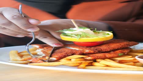 a person eating breaded chicken and french fries