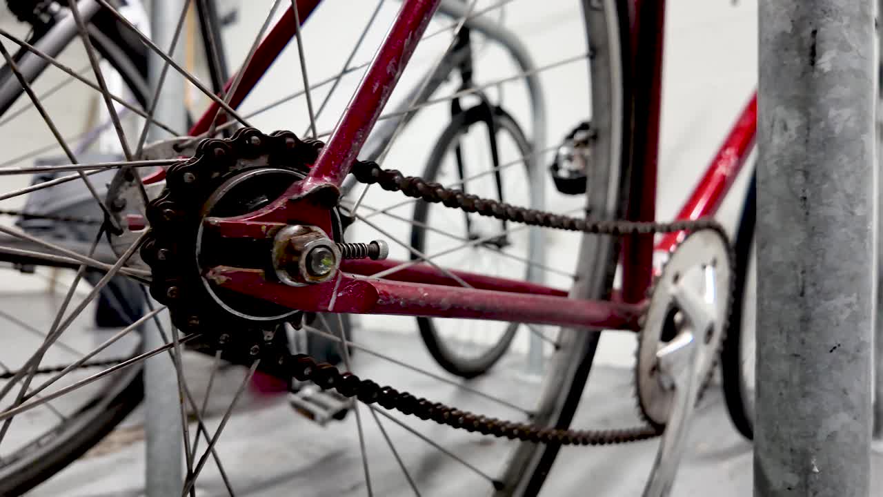 Close-up de bicicleta vermelha com corrente e raios enferrujados em conceitos de transporte de bicicletário, ciclismo urbano e manutenção de bicicletas, peças e reparos de bicicletas