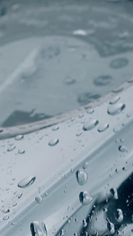 close view vibrating raindrops on wonderful black metal motorbike corpus with speedometer under glass