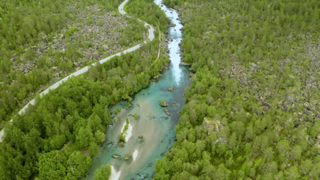 Vista-Aérea-Del-Río-Valldola-Con-Camino-Estrecho-Y-Sinuoso-Y-Bosque-Verde-En-Noruega