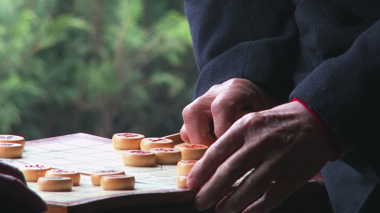 노인들은 중국의 한 공원에서 지나가는 사람들이 지켜보는 가운데 마작이나 중국 체커를 즐깁니다.