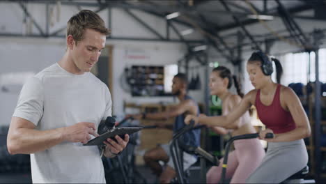 Gym-trainer-using-digital-tablet-to-monitor