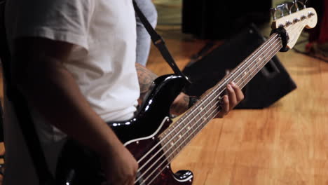 close up of hispanic bass guitar player performing concert