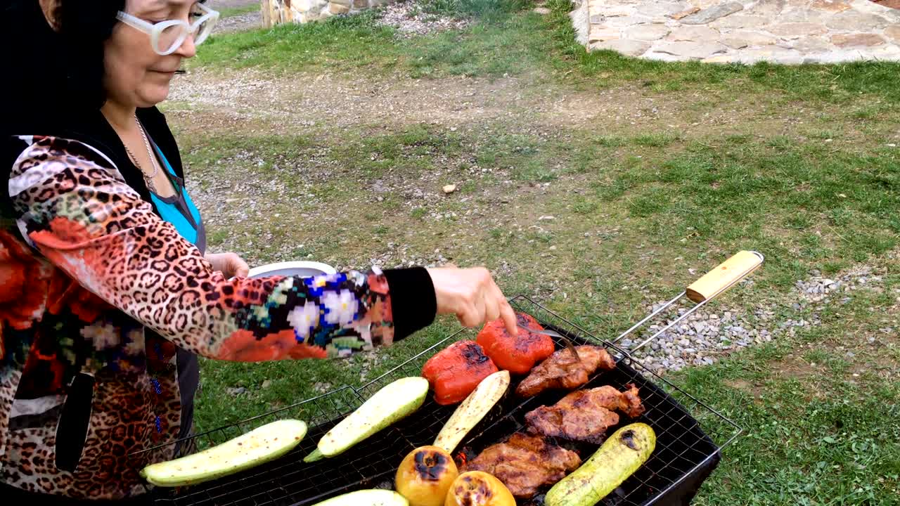 Dospělá žena připravuje nakládané chutné vepřové nebo hovězí maso a zeleninu.