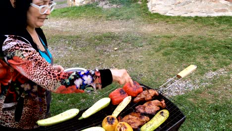 una mujer adulta prepara una saborosa carne de cerdo o carne de res y verduras en vinagre.