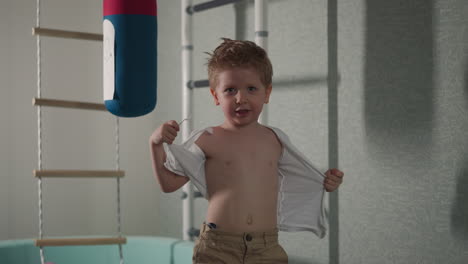 little boy in torn t-shirt imagines himself adult fighter