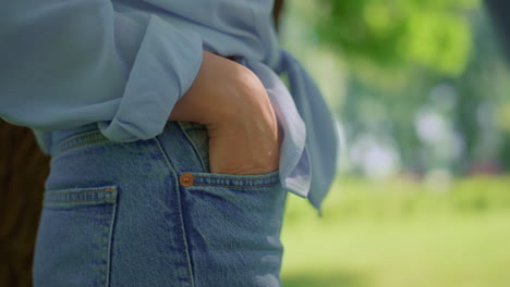 unknown woman hand in jeans pocket closeup. view of female arm in denim pants.