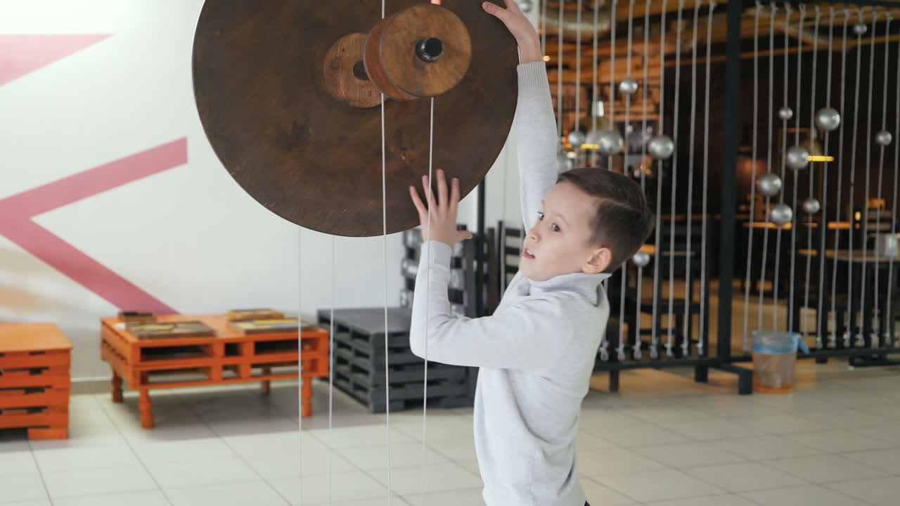 Mechanical conservation of energy. Maxwell's wheel. Boy conducts research experience.