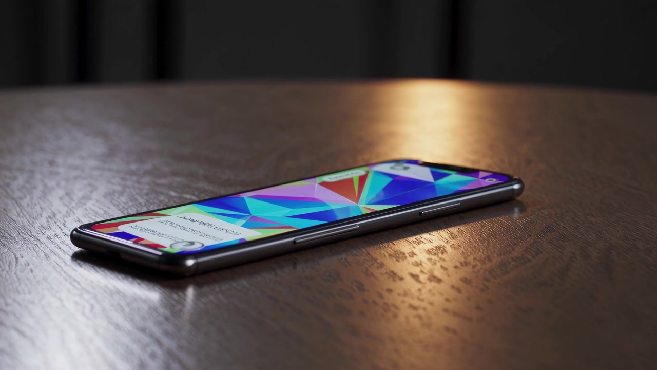 Smartphone moderno che mostra uno sfondo geometrico animato su un tavolo