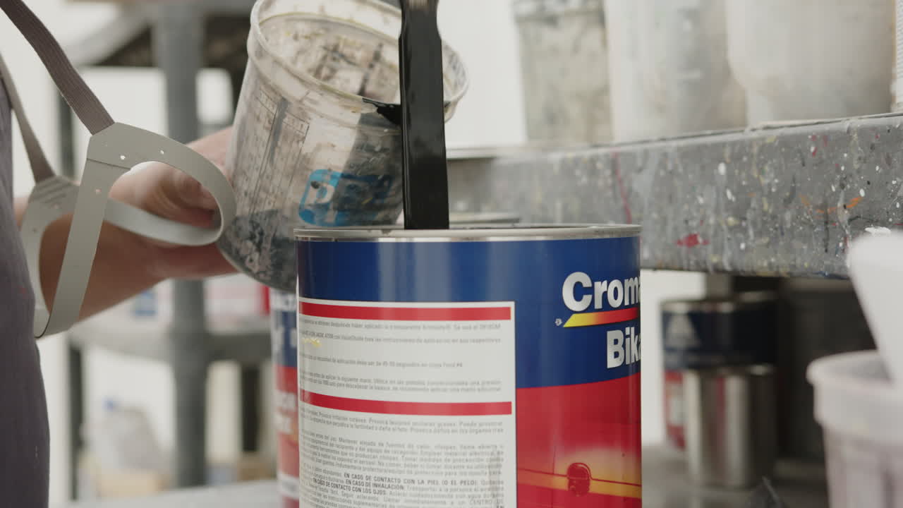 hombres que mezclan la preparación de la pintura negra con la pintura