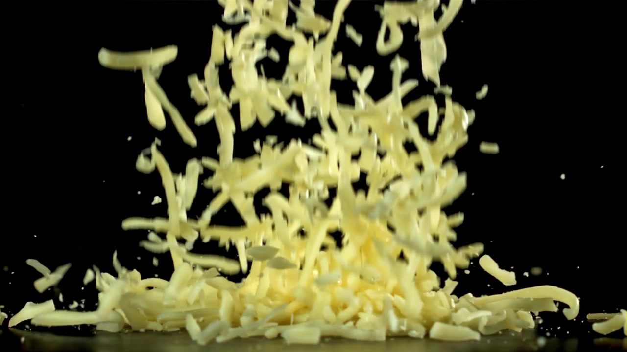 Shredded Cheese Falling in Slow Motion on a Black Background