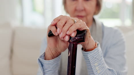 cane, hands and senior woman on sofa in living