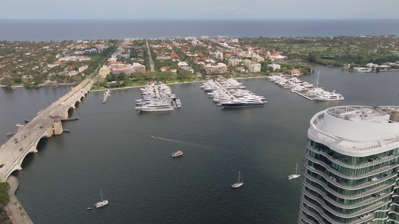 Aerial View of a Luxurious Marina with Yachts, Bridge, and Coastal City