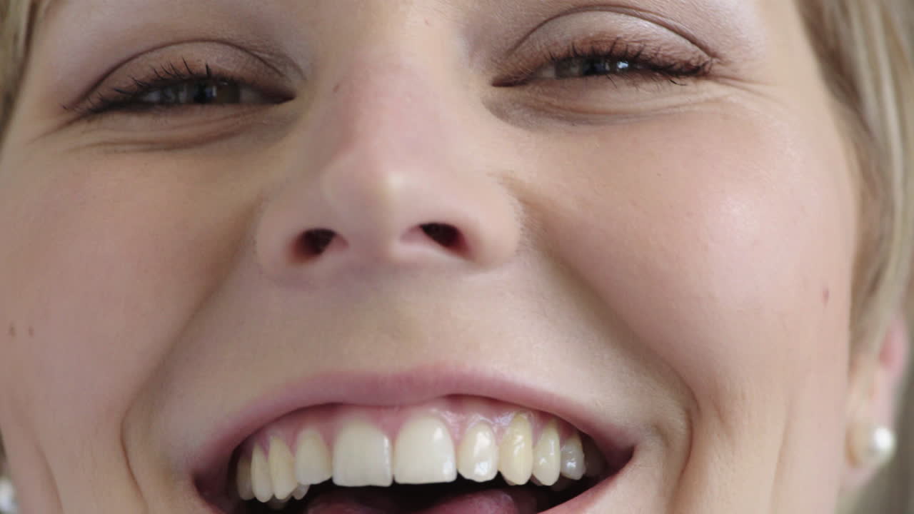 가까이서 아름다운 금발 여성의 눈이 카메라를 바라보며 웃고 즐겁고 건강한 시력을 즐기고 있습니다.