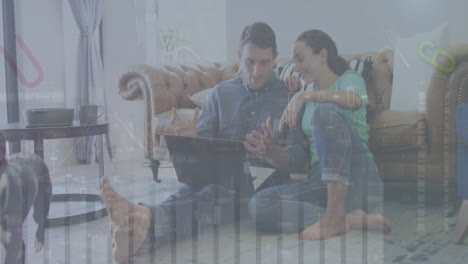 animación de múltiples gráficos y letras sobre una pareja caucásica hablando y usando una computadora portátil en casa