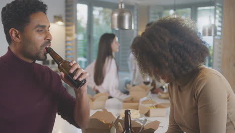 Group-Of-Multi-Cultural-Friends-Enjoying-Drinks-Party-With-Takeaway-Food-At-Home-Together