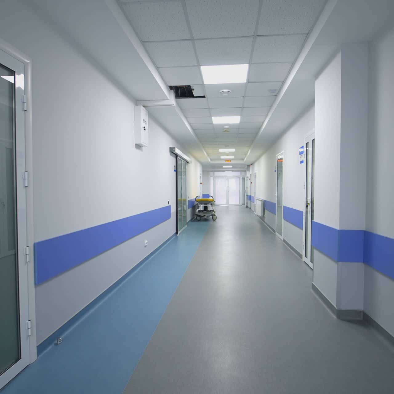 Corridoio vuoto in ospedale. Lungo e luminoso corridoio ospedaliero con stanze.