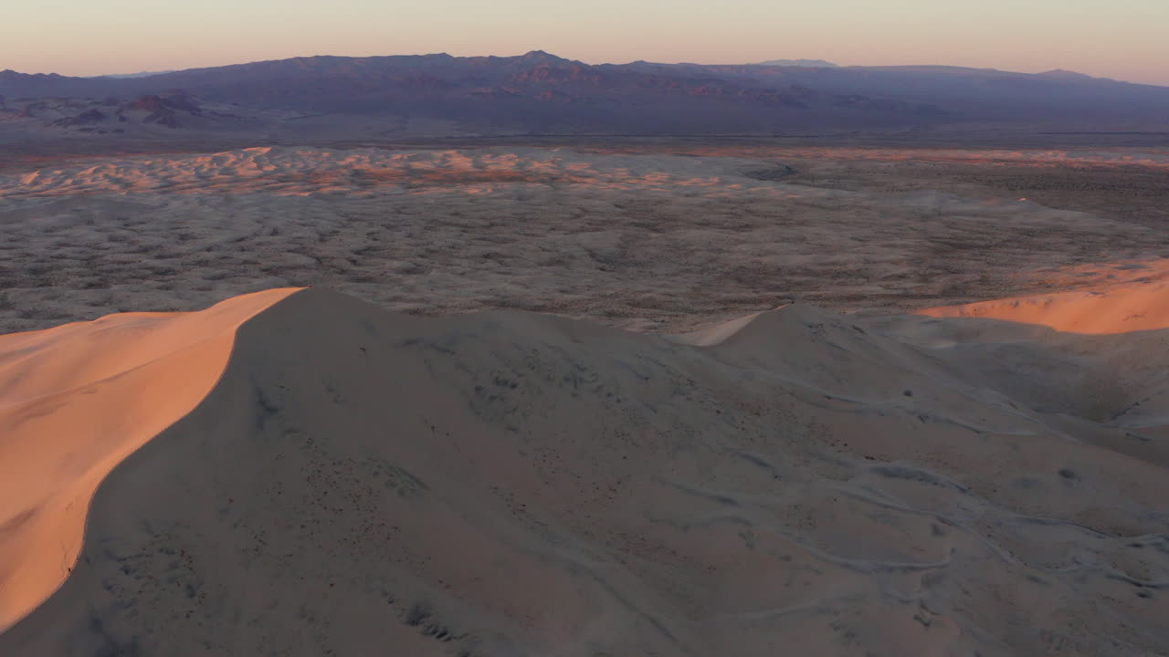 일몰 조명이 있는 모래 언덕의 공중과 사막의 그늘 쪽