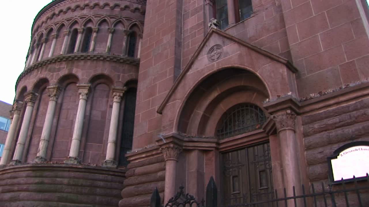 카메라는 장식에 초점을 맞추기 위해 붉은 돌 교회의 정면을 웜즈아이 뷰로 보여줍니다.