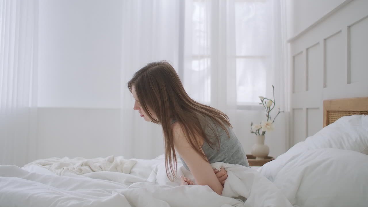 Young woman suffering from stomachache. Her menstrual cramps are too painful to go to work. woman suffering from stomach ache. suffering from severe pain and cramp in lower abdomen