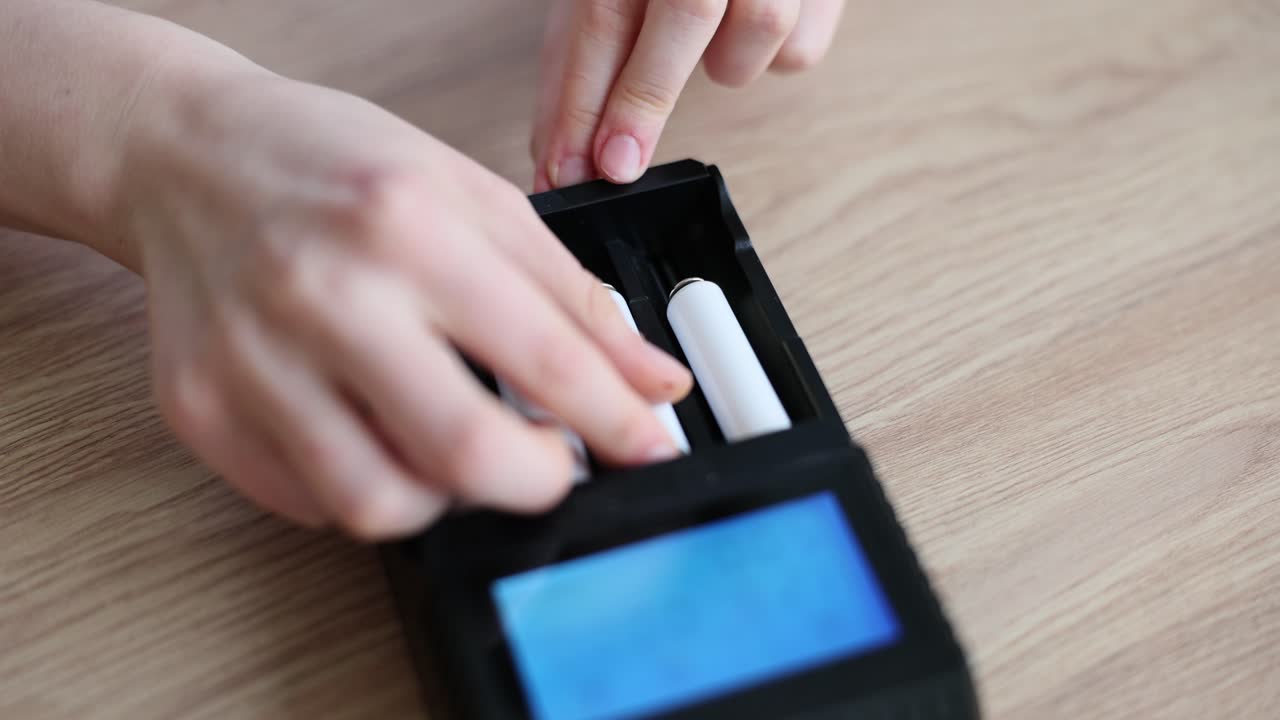 Person inserting or removing batteries from a charger
