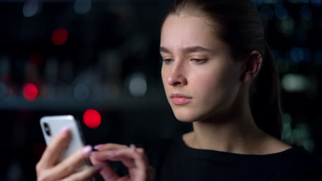 Portrait-of-concentrated-girl-surfing-internet-on-her-smartphone-outdoors.