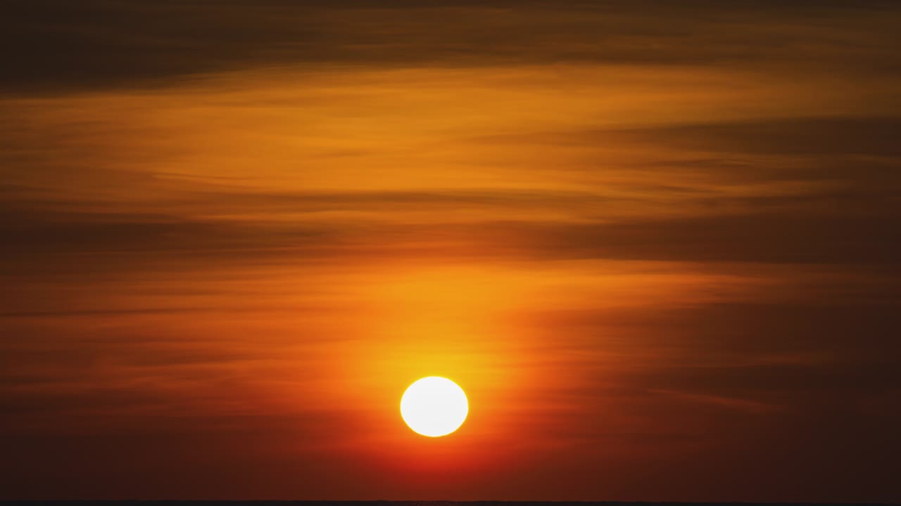 timelapse de una puesta de sol dorada en el extranjero. puesta de sol naranja redonda en el agua en la noche de verano. paisaje naturaleza amanecer fondo. imágenes b rollo de sol. cielo amarillo puesta de sol. hermoso océano tranquilo.