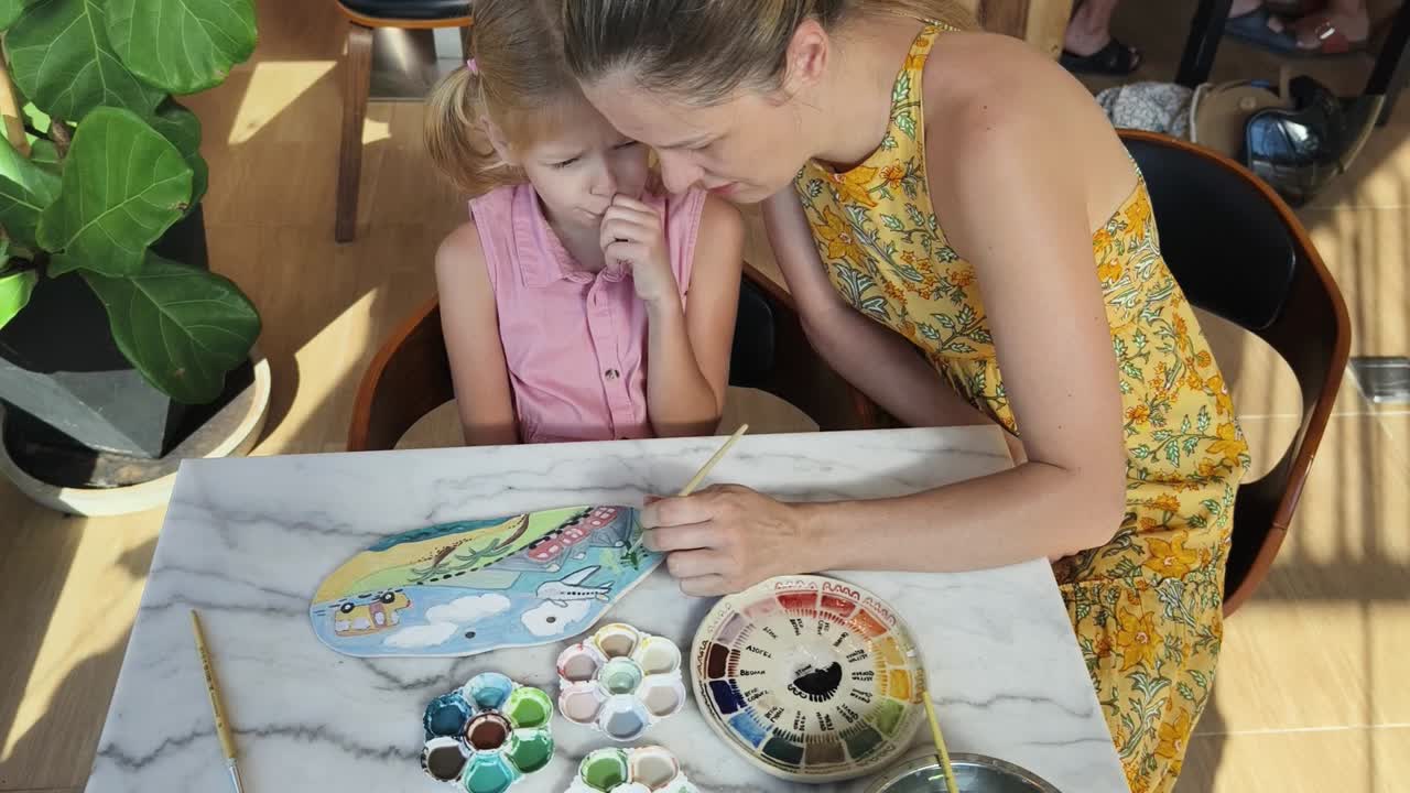 madre e hija pintando cerámica