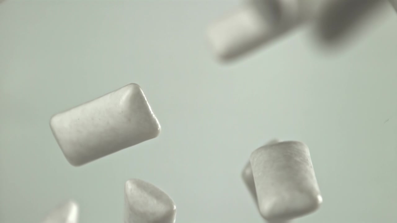 Pezzi di chewing gum bianchi che cadono al rallentatore
