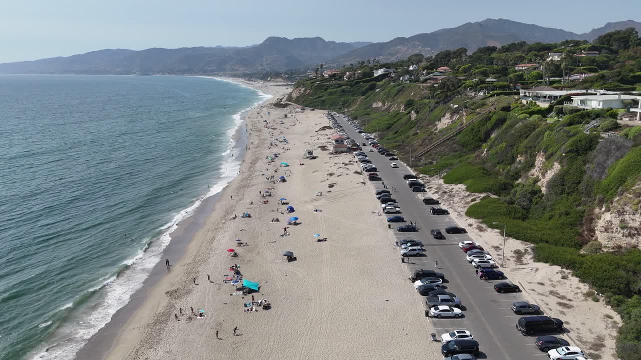 la gente disfruta de la playa de malibu en california.