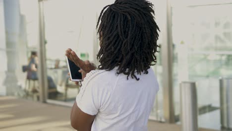 Excited-African-American-woman-with-dreadlocks-looking-at-phone.