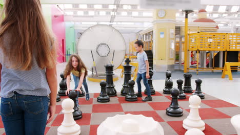 Four-kids-playing-giant-chess-at-a-science-activity-centre