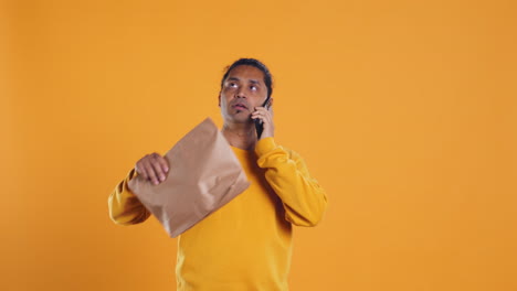 hombre haciendo entrega de comida contestando el teléfono, cumpliendo las órdenes de los clientes
