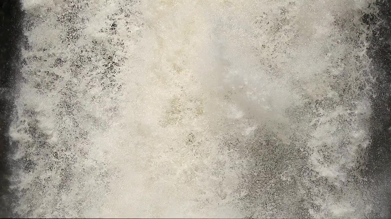 Potente cascata che scende a cascata lungo una parete rocciosa