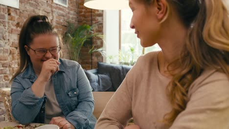 Down-syndrome-girl-and-her-friend-chatting-in-the-cafe