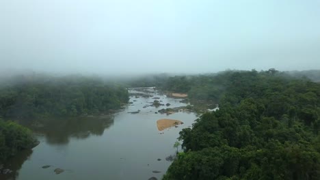 Aerial-shot-of-Amazon-River-flowing-through-misty-tropical-rainforest