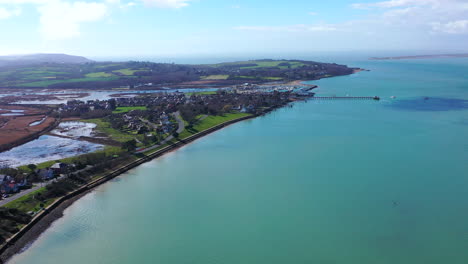 aerial flying towards isle of wight sea and village sunny day uk 4k