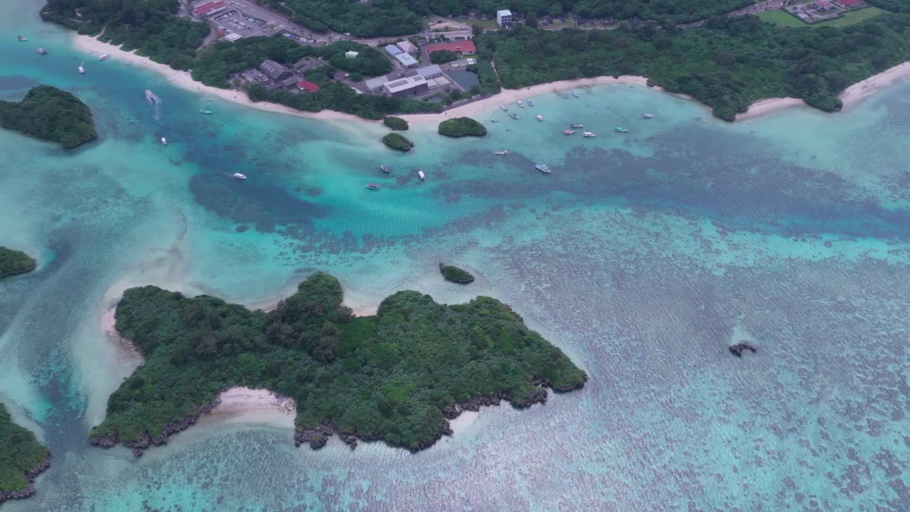 Riprese aeree orizzontali con movimento laterale a destra sopra la laguna turchese, le barriere coralline e gli isolotti boscosi della Baia di Kabira, vicino a Club Med e Tabaga Beach, Isola di Ishigaki, Okinawa, Giappone