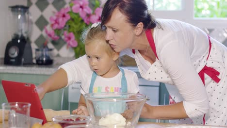 Mother-and-daughter-checking-a-baking-recipe