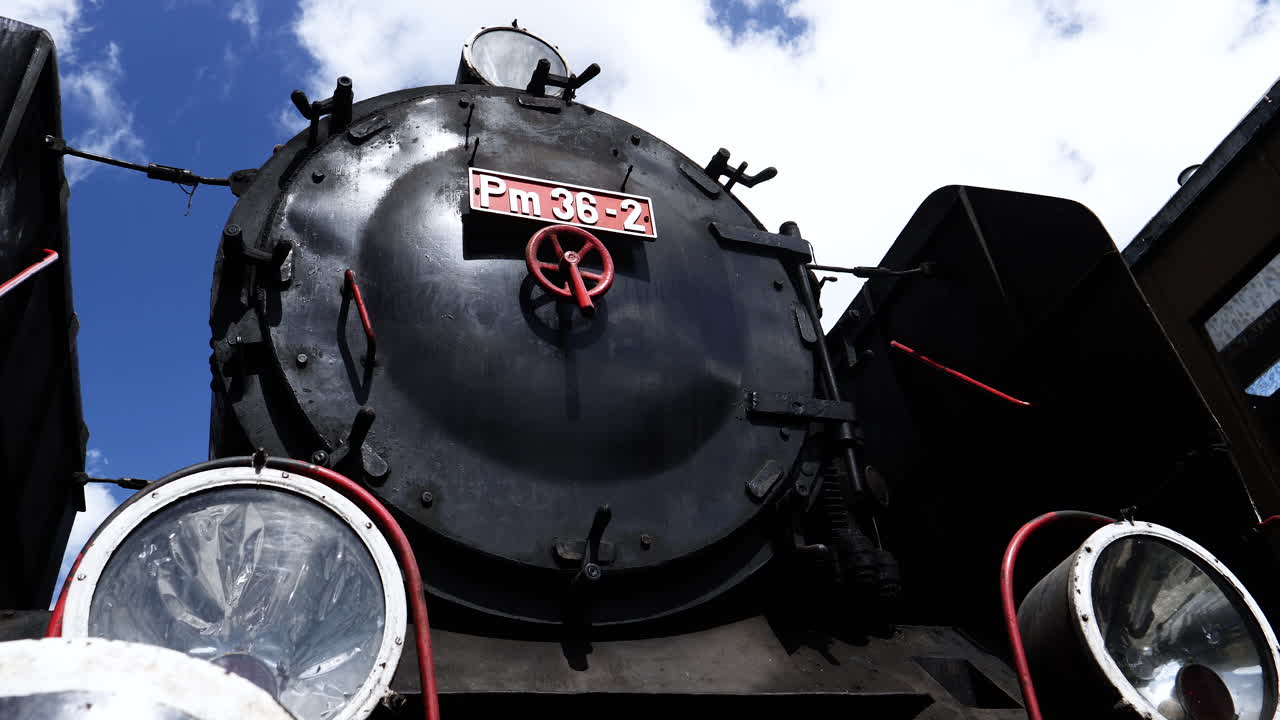 Time Lapse of vintage steam train front part with blue sky and clouds
